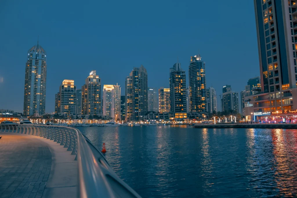 Dubai Marina bei Nacht: beleuchtete Hochhäuser an der Promenade Marina Walk